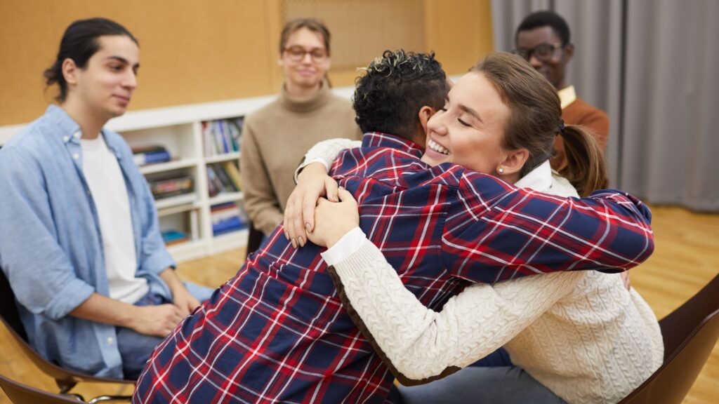 Mutual support during a group meeting at East MLK sober living program.